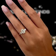 a woman's hand holding a diamond ring