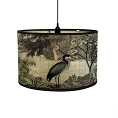 a lamp shade with a bird on it's side and an egret in the background