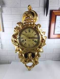 a gold clock sitting on top of a white table