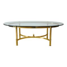 an oval glass table with gold metal legs