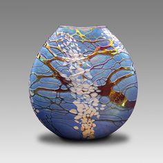 a glass vase with an artistic design on it's body and branches in the center