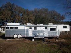 the trailer is parked on the side of the road in front of some houses and trees