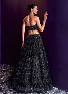 Elevate your style with the exquisite Black Sequins Embroidered Bridal Lehenga Set, a true masterpiece of craftsmanship and design. Crafted from soft net, the black lehenga is beautifully adorned with intricate embroidery featuring tonal and gunmetal sequins, glass pipes, and shimmering crystals, creating a mesmerizing interplay of light and texture. Teamed with a stylish tube-cut blouse, this set adds a contemporary twist to the traditional silhouette, offering a flattering and modern fit. The ensemble is completed with a matching embellished dupatta that exudes sophistication, making it a perfect choice for brides or brides-to-be looking to make a statement at cocktail parties, ensuring you stand out with grace and style on your special day. Composition : Lehenga, Blouse and Dupatta - Ne Embroidered Bridal Lehenga, Cut Blouse, Black Lehenga, Lehenga Blouse, Cocktail Parties, Intricate Embroidery, Glass Pipes, Bridal Lehenga, Black Sequins