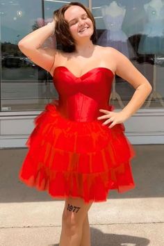 a woman in a red dress posing for the camera