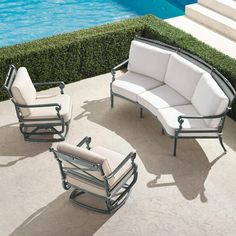 an outdoor seating set near a pool with water in the backgroung area