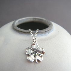 sterling silver cherry blossom necklace, 1/2" - A sterling silver cherry blossom, measuring 1/2" (12 mm) across and down.   - Necklace is 1.5 mm cable chain, with lobster clasp and locking jump rings, all solid sterling silver.  - Charm has blackening (oxidizing) to bring out the details. - Flower is realistic looking, with petal ends slightly curled over.  - Back is smooth and has a tiny 925 mark. - Packaged in a modern circular tin, ready for gift giving, and comes with a silver polish pad and Cheap Sterling Silver Necklaces With Flower Charm, Cherry Blossom Jewelry, Cherry Blossom Necklace, Sterling Silver Cleaner, Top Rings, Flower Jewellery, Everyday Jewelry, Flower Pendant, Small Flowers