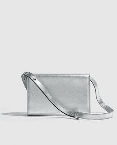 Silver metallic party bag with structured design, light and versatile. Vintage inspired.      

Made in bovine leather with metallic finish. 
Flap with magnetic clip closure.     
Adjustable and detachable long leather handle.
Open inside pocket. 
Designed and manufactured entirely in Spain using sustainable processes and small productions.
W17 cm x L25cm x D6 cm. Silver Rectangular Box Bag With Removable Pouch, Rectangular Silver Box Bag With Removable Pouch, Silver Box Clutch For Everyday Use, Modern Metallic Party Bag, Modern Metallic Party Bags, Luxury Metallic Rectangular Clutch, Modern Rectangular Clutch With Silver-tone Hardware, Modern Rectangular Evening Bag With Silver-tone Hardware, Modern Clutch With Silver-tone Hardware