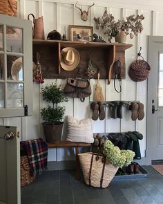 an entryway with baskets, hats and other items hanging on the wall above it