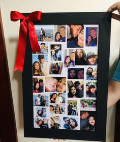 a person holding up a black framed photo with red ribbon around it's edges