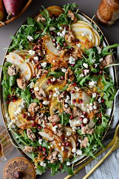 a salad with pears and goat cheese on top is served in a large bowl