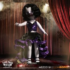 a creepy doll dressed in purple and black is posing for the camera with red curtains behind her