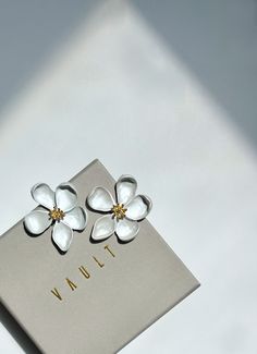 These floral earrings are effortlessly chic in design, and versatile in style and wearability.  They are light in weight and pack the ultimate statement!  The silky white coating of this earrings is high quality and makes for a very smooth and consistent sheen. Elegant White Flower Pendant Earrings, Chic Silver Flower Jewelry, Chic White Flower-shaped Earrings, Chic Flower Earrings As A Gift, Chic Silver Flower Earrings For Pierced Ears, Chic Flower Earrings With Flower Charm, Chic Flower Charm Earrings For Gift, Chic Flower Charm Earrings As Gift, Chic Silver Flower Earrings