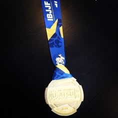 a blue and yellow medal is hanging on a black table with the words btube written on it