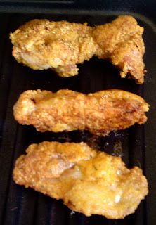 three fried chicken pieces on top of a grill