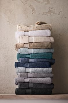 towels stacked on top of each other in different colors and sizes, all lined up