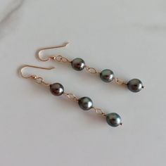 Triple Tahitian Pearl Earrings~ These elegant earrings have genuine Tahitian pearls linked with 14k gold fill diamond links. This listing is for the earrings in the first photos Pearls approx. 9mm. Dangles approx. 2.75" from bottom of earwire *Models wearing similar design Tahitian pearl jewelry~ https://www.etsy.com/shop/HanaMauiCreations?ref=hdr_shop_menu&section_id=7842721 Shop~ http://www.etsy.com/shop/HanaMauiCreations?ref=pr_shop_more International buyers please read our shipping policies Tahitian Pearls Jewelry, Tahitian Pearl Earrings, Pearl Earrings Gold, Gold Pearl Earrings, Fashion Elegant, Tahitian Pearls, Wedding Fashion, Maui Hawaii, Elegant Earrings