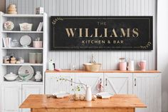 the williams kitchen and bar sign is displayed in front of a wooden table with dishes on it