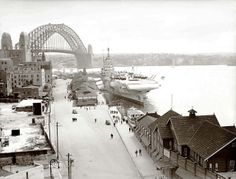 an old black and white photo of a large ship in the water next to some buildings