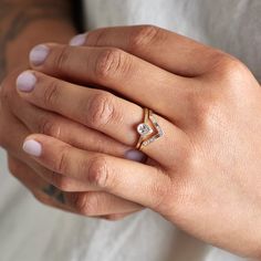 a woman's hand with a diamond ring on it