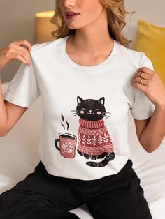 Embrace the cozy vibes with our adorable unisex T-shirt featuring a cute black cat wearing a red sweater, accompanied by a steaming cup of coffee. Perfect for cat lovers and coffee enthusiasts alike, this shirt combines warmth and charm in one delightful design. Made from high-quality materials, it ensures comfort and style for any casual occasion. Ideal as a gift or a personal treat, this T-shirt will keep you feeling snug and stylish. Available in various sizes for both men and women. We utili Cat Lover Shirt, Cute Black Cats, Coffee Enthusiast, Red Sweater, Cozy Winter, Red Sweaters, Unisex Design, Cat Lover, Hot Coffee