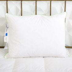 a white pillow sitting on top of a bed next to a wall with geometric designs