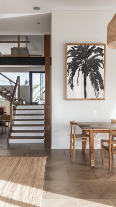 a dining room table and chairs in front of a staircase