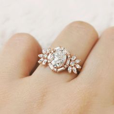 a close up of a person's hand with a diamond ring on their finger