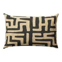 a black and white pillow with an abstract design on the front, sitting on a white background