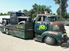 an old green tow truck with a fish decal on it's flatbed