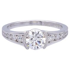 a diamond engagement ring with channel set diamonds on the sides and an oval center stone