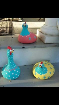 three colorful birds sitting on top of some cement steps with polka dots and blue spots