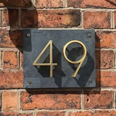 a brick wall with a metal number sign on it