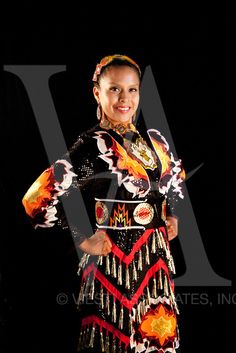 a woman in a colorful dress posing for the camera with her hands on her hips