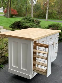 a kitchen island with drawers in the middle of it and an open drawer on top