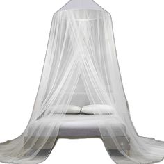 a white canopy bed with mosquito netting over it's head and pillows on top