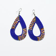 Handcrafted Maasai beaded earrings in a teardrop shape with vibrant colors. Each set is multicolored measuring 2.5 in tall and 1.5 in wide. Perfect for beach trips, summer getaways, evening parties, bridal party gifts, birthday gifts, or gifts for her. Traditional Teardrop Earrings With Tiny Beads, Gift Teardrop Earrings With Colorful Beads, Beaded Teardrop Earrings As Gift, Beaded Teardrop Earrings For Gift, Traditional Teardrop Beaded Earrings With Tiny Beads, Handmade Multicolor Teardrop Hoop Earrings, Blue Teardrop Hoop Earrings With Dangling Beads, Blue Teardrop Jewelry With Colorful Beads, Multicolor Beaded Teardrop Earrings