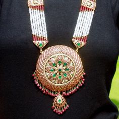 A long necklace set (Rani haar) in gold plated silver set with pearls and synthetic red and green stones that resemble rubies and emeralds. The stringing and hanging beads are pearls and real rubies and emeralds. Weight: 180gms Default Materials in Our Gold Plated Jewellery Metal: 925 Sterling Silver Studded Stones: Precious freshwater pearls, synthetic red,green,blue stones that resemble rubies, emeralds & sapphires. Turquoise and Navaratna jewelry come with a mix of real & synthetic depending Temple Jewelry Beaded Necklace With Intricate Design For Festivals, Ceremonial Temple Jewelry Pearl Necklace With Intricate Design, Temple Jewelry Style Pearl Pendant Necklace For Celebrations, Traditional White Ruby Bridal Necklace, Round Pearl Pendant Necklace For Festivals, Traditional Hand Set Pearl Necklace For Festivals, Traditional Hand-set Pearl Necklace For Festivals, Traditional Green Jewelry With Pearl Pendant, Temple Style Kundan Necklace With Pearl Pendant