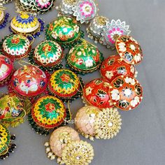 there are many different colored ornaments on the table and one has a heart shaped brooch