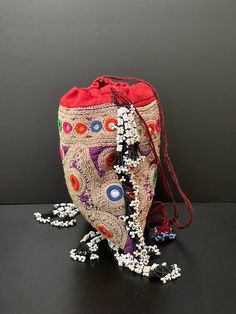 a drawstring bag sitting on top of a black table next to some beads