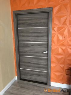 an orange room with a grey door and wooden floor