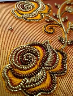 an embroidered fabric with gold thread and beads