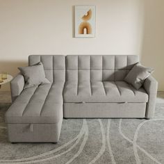 a living room with a large gray sectional couch and coffee table on the carpeted floor