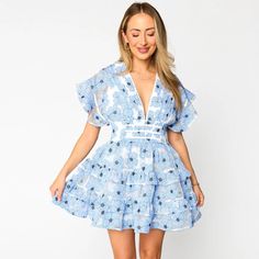 Beautiful Jacey Features A Flutter Sleeve, Plunging Neckline, And Beautiful Pattern In The Color Blue Lagoon. This Dress Runs True To Size. This Darling Mini Dress Is Perfect For Any Special Occasion. Flirty V-neck Spring Dress, Light Blue V-neck Mini Dress For Vacation, Light Blue V-neck Mini Dress With Ruffle Hem, Feminine Blue V-neck Dress, Light Blue Ruffled V-neck Mini Dress, Light Blue V-neck Mini Dress With Ruffles, Flirty Beach Dress With Flutter Sleeves, Blue V-neck Spring Dress, Light Blue Ruffle Dress For Date Night