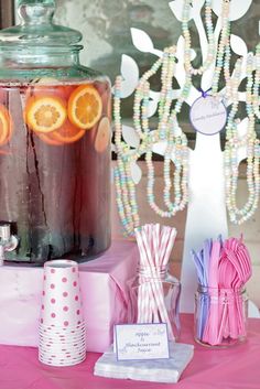 a table topped with jars filled with liquid and orange slices