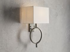 a wall light with a square shade on it's side and a ring around the lamp