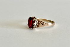 Beautiful antique circa 1800s Mid Victorian era 10k rosey gold created ruby ring! This stylish solitaire style ring features a oval faceted 1.25 carat created deep red gemstone. The stone is securely prong set in a crown style setting, with detailed shoulder work. A fantastic piece of fine mid Victorian era jewelry, featuring July's birthstone!  ERA - Circa 1861-1887 / Mid Victorian  METAL / MATERIAL - 10k rose gold, created ruby  (approx. 1.25CT)  [Synthetic ruby contains essentially the same c Victorian Oval Ruby Ring, Victorian Rose Gold Ruby Ring, Antique Rose Gold Ruby Jewelry, Antique Oval Solitaire Jewelry, Victorian 14k Gold Ruby Ring In Red, Victorian Ruby Ring In 14k Gold, Vintage 14k Rose Gold Ruby Ring, Classic Oval Rose Gold Ruby Ring, Vintage Rose Gold Ruby Ring