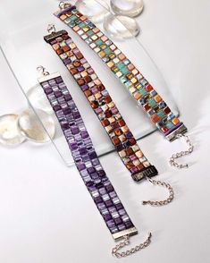 three bracelets are sitting on a glass plate