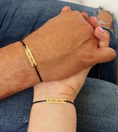 a man and woman holding hands while wearing bracelets