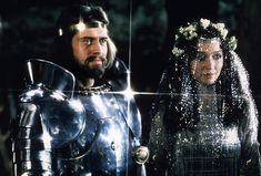 a man and woman dressed in armor standing next to each other