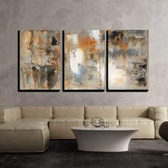 three abstract paintings hang on the wall in a modern living room with white couches